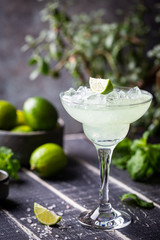 margarita cocktail with lime in a glass on dark background