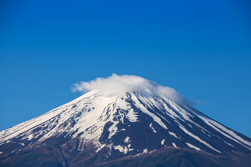 Fototapeta na wymiar Close up top of beautiful Fuji mountain with snow cover on the top with could, Mount Fuji, Fujisan located on Honshu Island, is the highest mountain in Japan.