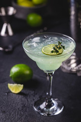 margarita cocktail with lime in a glass on dark background