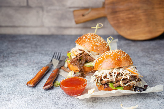 Pulled beef burger with cabbage salad and bbq sauce on paper