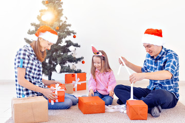 Holidays and presents concept - Portrait of a happy family opening gifts at Christmas time