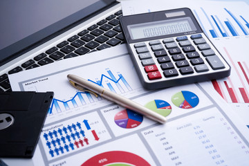 Business and finance with analytical study on market trend or demand with document on paper, calculator, laptop and a pen