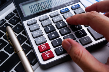 Business and finance with analytical study on market trend or demand with document on paper, calculator, laptop and a pen