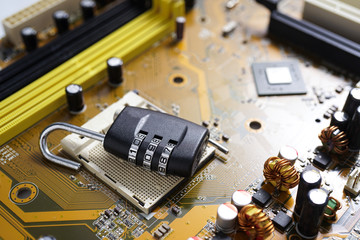 Padlock lying on PC Mainboard symbolizing Computer Cyber Security Concept