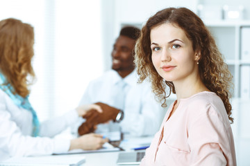 Obraz premium Business woman at meeting in office, colored in white. Multi ethnic business people group
