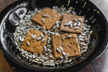 wheat crackers shooted with different  vegetables,groats,honey,seeds,salt on different surfaces