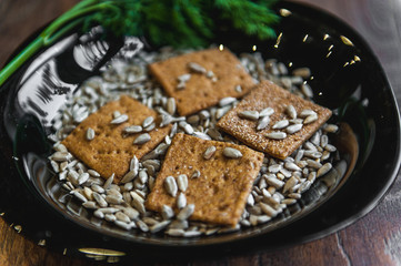 wheat crackers shooted with different  vegetables,groats,honey,seeds,salt on different surfaces