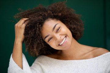 Close up beautiful young african american woman smiling with hand in hair