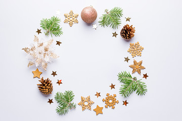 Christmas round frame with fir tree branches, painted pine cones, confetti on grey background, copy...