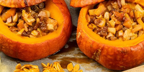 baked pumpkin in the oven with raisins and apples