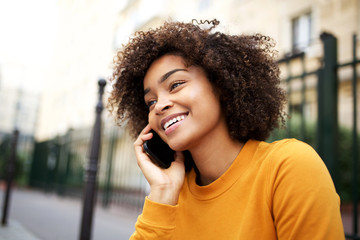 happy african american young woman talking with cellphone in city - Powered by Adobe