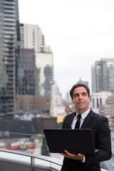 Handsome Persian businessman against view of the city