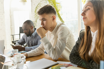 Group of young business professionals having a meeting. Diverse group of coworkers discuss new decisions, future plans and strategy. Creative meeting and workplace, business, finance, teamwork.