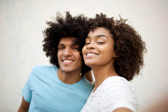 Close up happy african american couple taking selfie by white wall