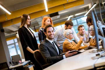 Senior businesswoman working together with young business people in office