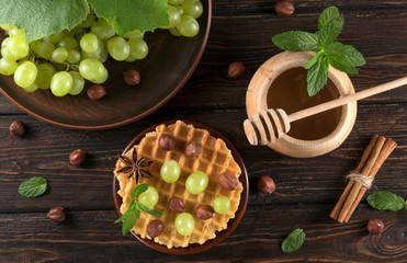 Fototapeta premium .waffles with grapes and honey on a wooden background