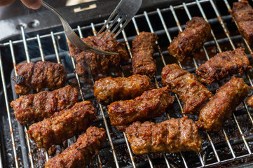 Man turn around grilled meat on the grill - garden party scene