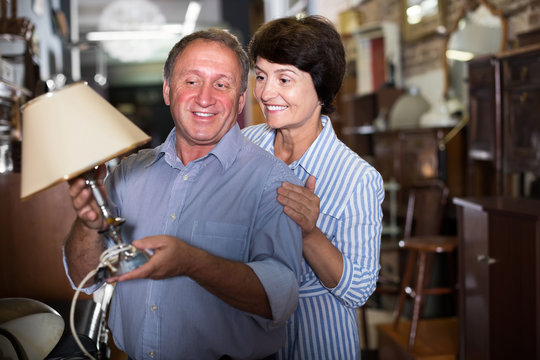 Woman with her husband are buying antique lamp