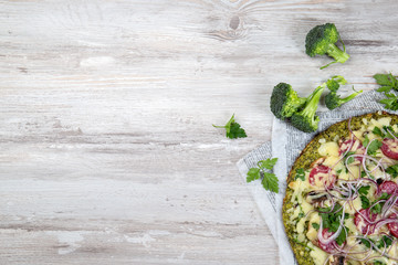 Crust Broccoli base low carbs keto pizza with salami, avocado on vintage newspapper. Top view