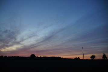 Abendliche Cirrostratus-Wolken über ländlicher Silhouette