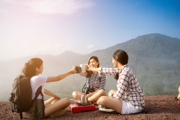 Group of Friends asian camp nature. Adventure Travel Relax Concept, mountain view.Group of Asian female tourists at the camp and drinking coffee in the mountains.