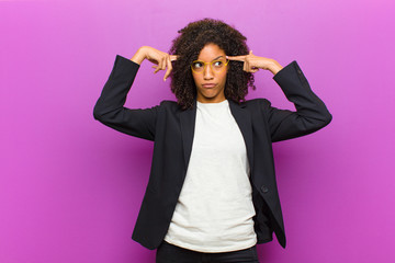 young black business woman with a serious and concentrated look, brainstorming and thinking about a...