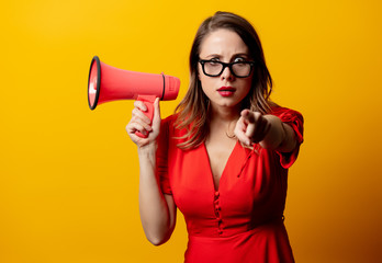 Naklejka premium Beautiful woman in red dress with loudspeaker