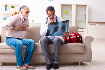 Young male doctor visiting old patient at home