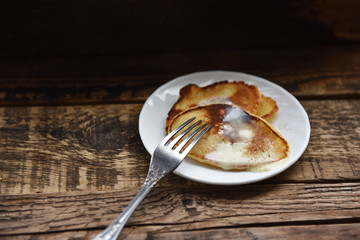 pancakes with condensed milk on a wooden table
