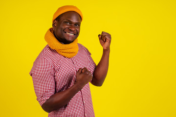 portrait of success attractive african american man in knitted hat and scarf and red checkered shirt excited feeling good-mood.autumn spring fashion look outfit