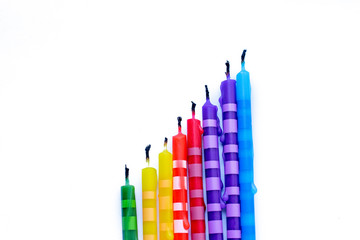 eight extinguished multicolored birthday candles on a white background
