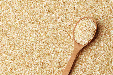 Amaranth in a wooden spoon on the background of porridge