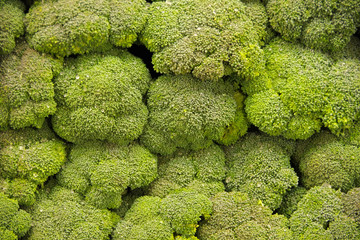 Close-up full frame top view of fresh broccoli crowns displayed at a market stand