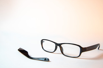 Broken bow near glasses on white background