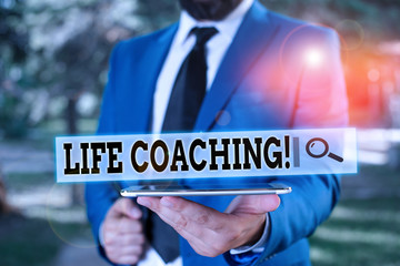 Handwriting text Life Coaching. Conceptual photo demonstrating employed to help showing attain their goals in career Businessman in blue suite stands with mobile phone in hands