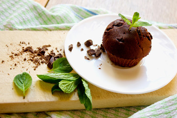 Top View of Chocolate Muffin with Mint Leaves on the Saucer in t
