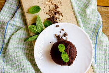Top View of Chocolate Muffin with Mint Leaves on the Saucer in t