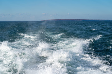 The wake from a boat ride on Lake Superior. Apostle Islands in the distance