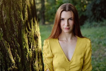 Portrait Of Redhead Young Woman Standing Near Tree