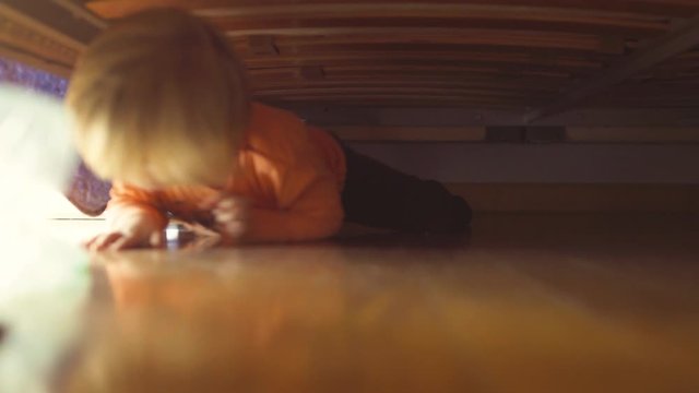 little boy playing under the bed