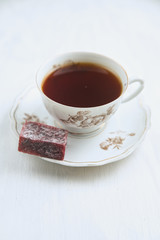 Porcelain tea pair with tea and berry marmalade on a plate
