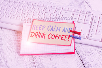 Writing note showing Keep Calm And Drink Coffee. Business concept for encourage demonstrating to enjoy caffeine drink and relax notebook reminder clothespin with pinned sheet light wooden