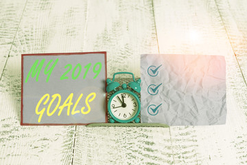 Text sign showing My 2019 Goals. Business photo text setting up demonstratingal goals or plans for the current year Mini blue alarm clock standing above buffer wire between two notation paper