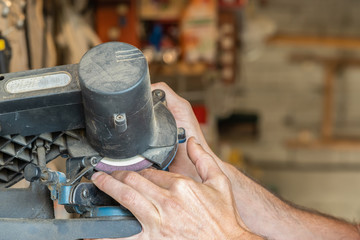 man hands Cutting his fingers with industrial machinery with workshop in the background