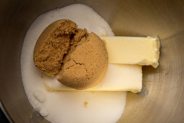 Brown sugar is added to a mixing bowl for cookies
