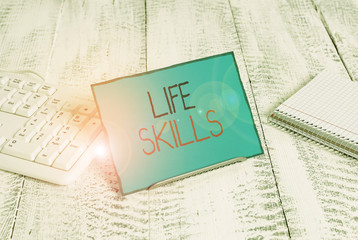 Naklejka premium Writing note showing Life Skills. Business concept for skill that is necessary for full participation in everyday life Notepaper on wire in between computer keyboard and sheets