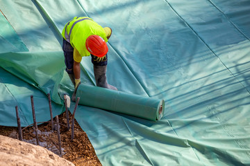 Installing plastic vapor barrier before pouring concrete slab