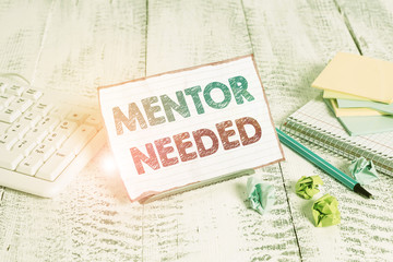 Text sign showing Mentor Needed. Business photo showcasing wanted help for more experienced or more knowledgeable demonstrating Notepaper stand on buffer wire in between computer keyboard and math