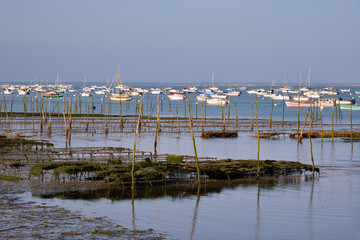 Fototapeta na wymiar Oyster farming and boats at Cap-Ferret, a commune is a located on the shore of Arcachon Bay in the Gironde department in Aquitaine in southwestern France