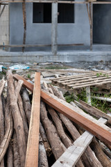 Pile of timber wood used for scaffolding and structure in house building construction in Thailand.